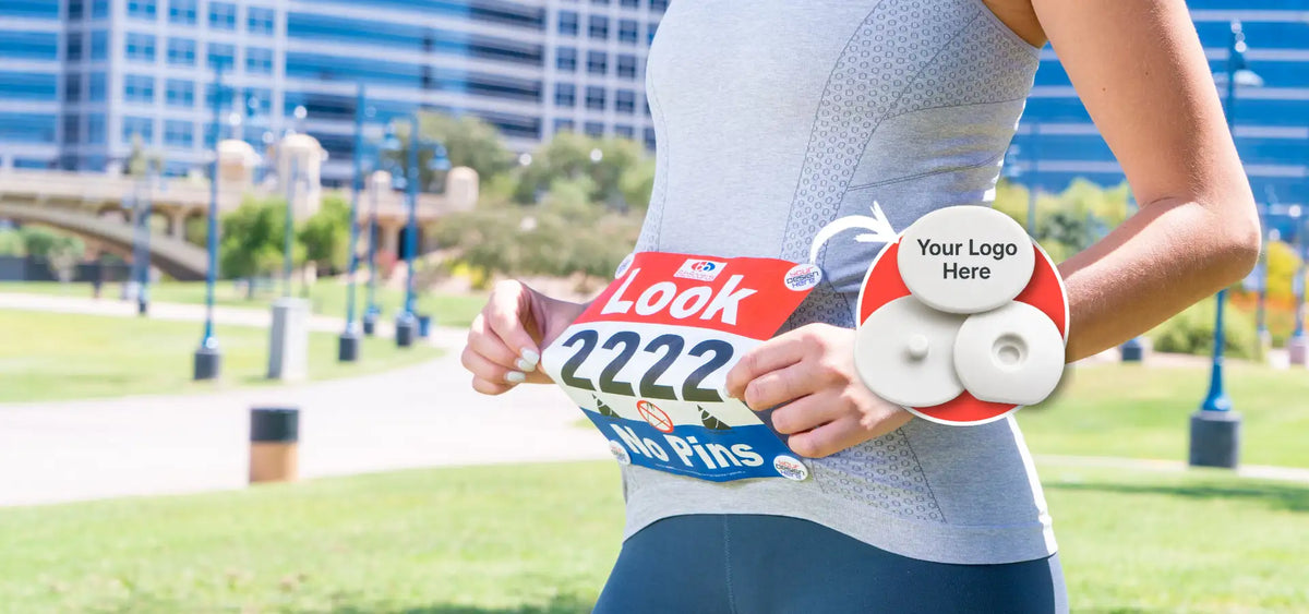 The two bibSNAPS pieces, a base and a branded top, holding a race bib